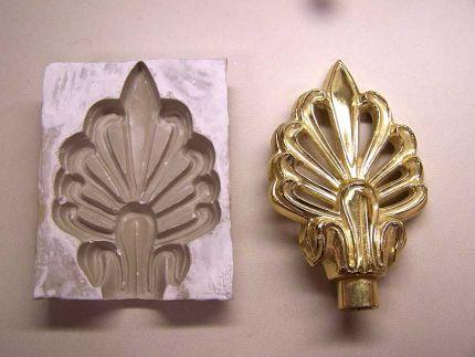 A medallion mold with a gold medallion freshly removed from it